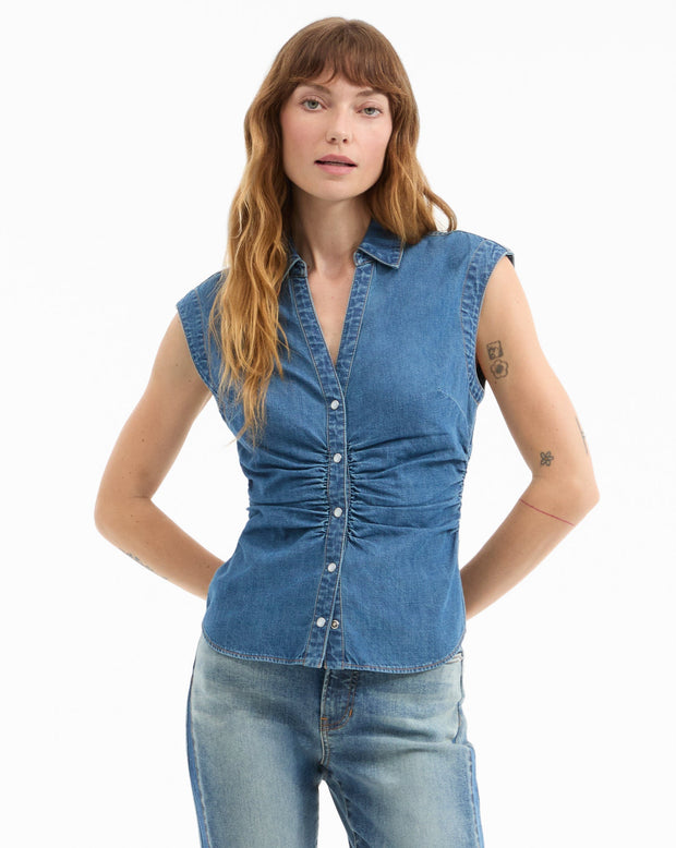 Woman wearing a blue denim sleeveless shirt on a white background
