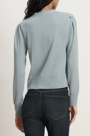 Light blue sweater worn by a person on a plain background