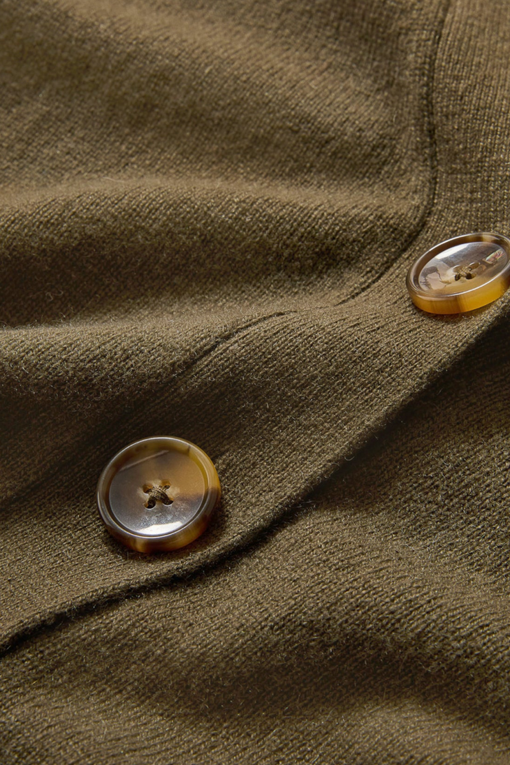 Close-up of a green fabric with buttons on a garment.