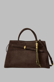 Brown handbag with vegan leather bag charm and gold accents on a white background