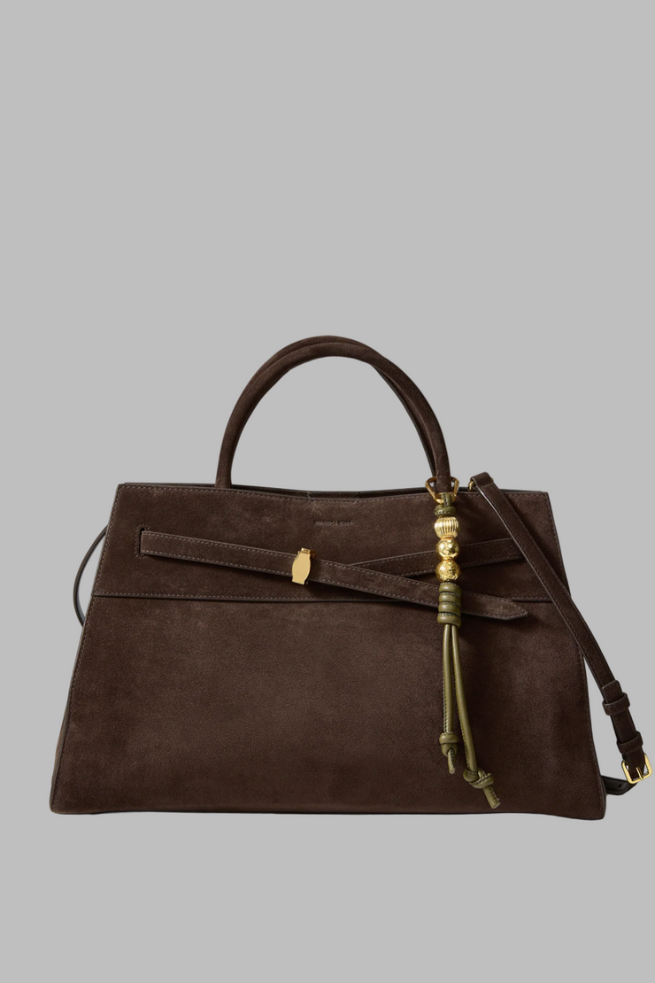 Brown handbag with vegan leather bag charm and gold accents on a white background