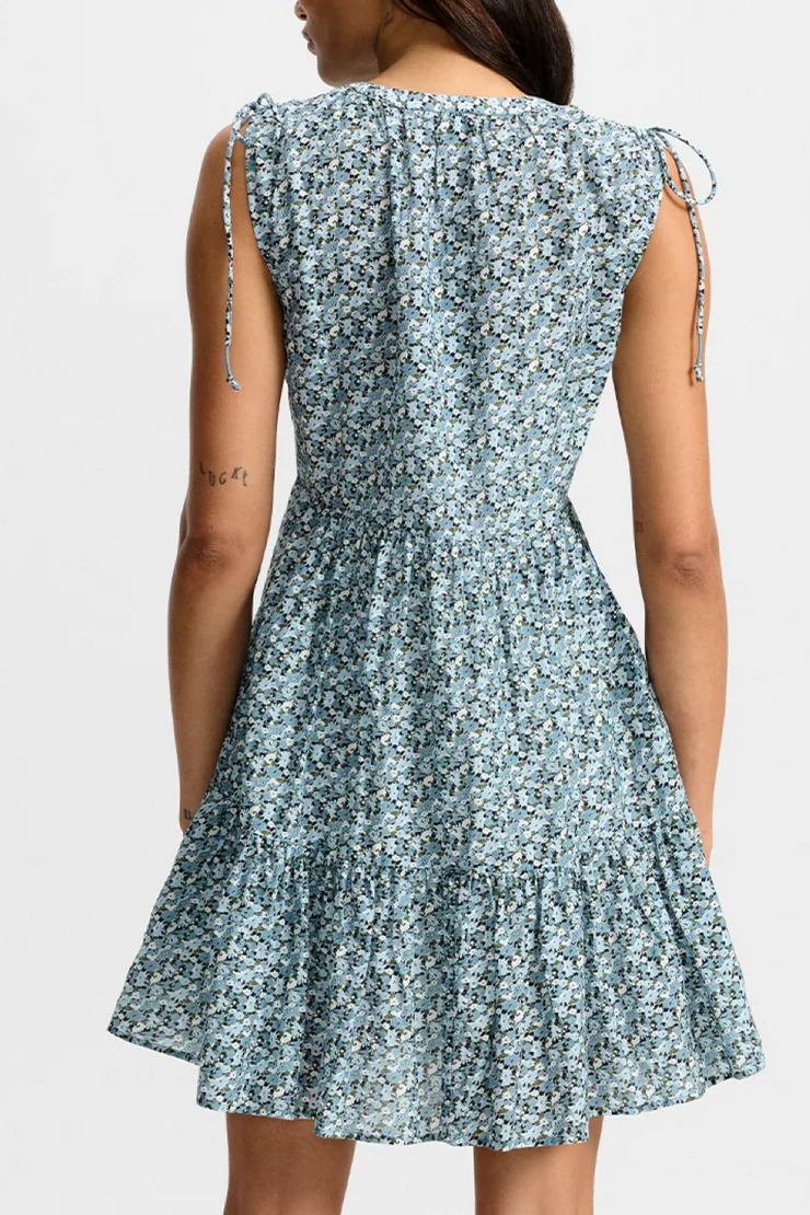 Woman wearing a floral dress with thin straps on a white background