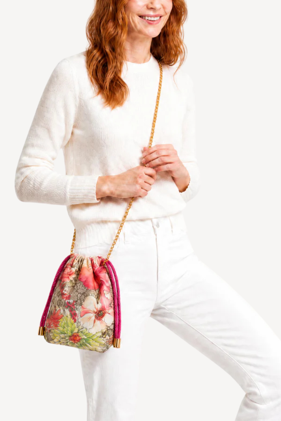 Woman holding a floral handbag against a white background