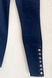 Image of the L'AGENCE Piper H/R Skinny hanging on hanger against white wall,  close up of button detail