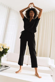 Image of model wearing the SUNDAYS Malone Pant, standing on table with hands over head, front view 